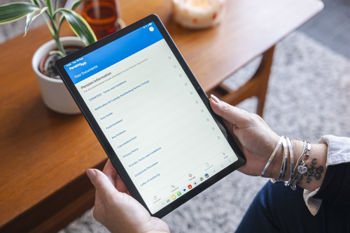 An image showing someone holding a tablet, displaying the Pension App documents page.