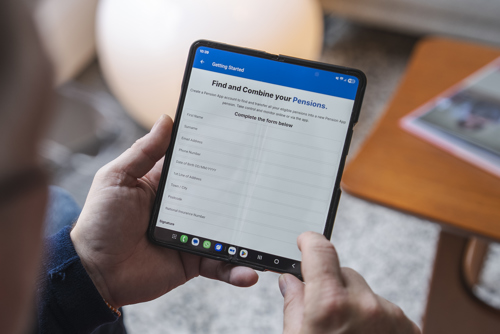 An image showing someone holding a phone, displaying the Pension App signup page.